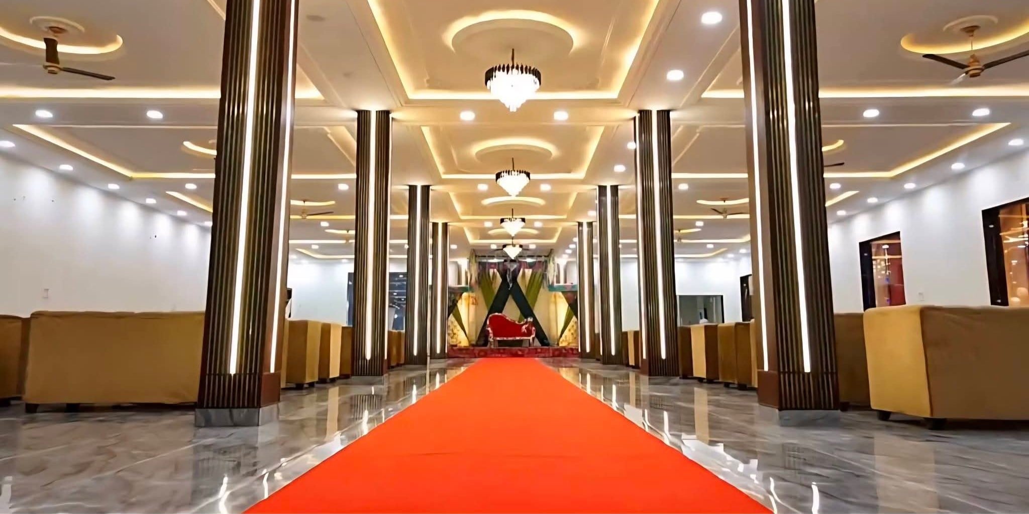 Indoor hall with illuminated pillars, lights, and red carpet aisle