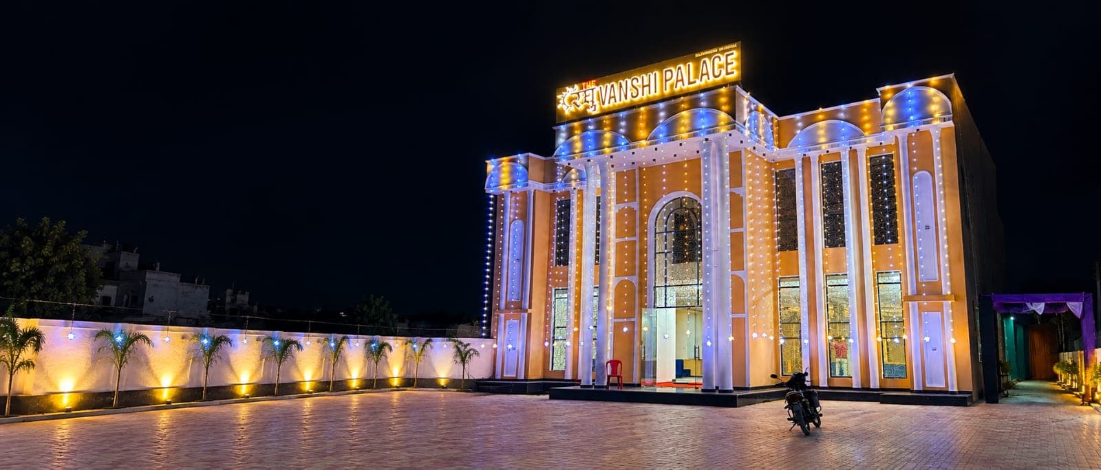 Illuminated architectural facade of Raghuvanshi Palace with royal golden pillars and courtyard